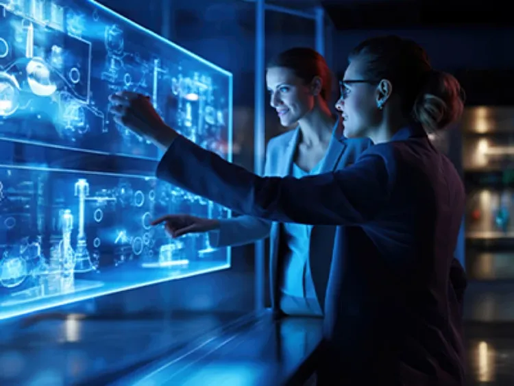 Two female colleagues looking at computerized data screen.