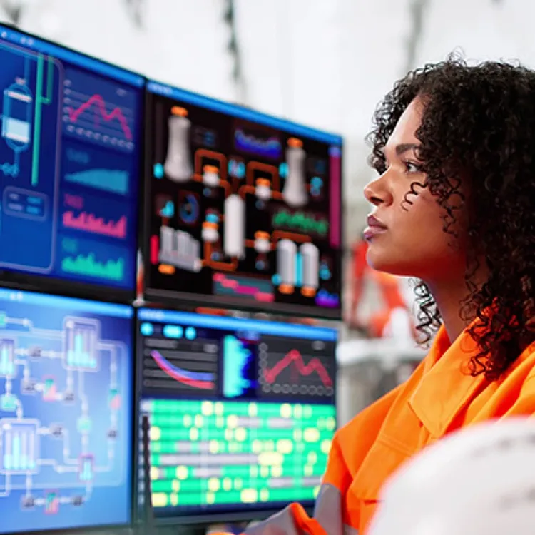 Female employee looking at multiple computer screens.