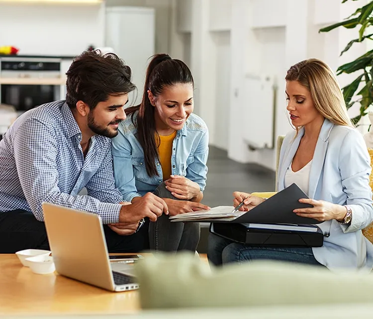 Three colleagues sitting on a couch and talking while studyng a document