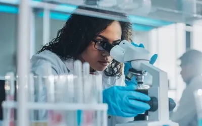 A female looking at a laptop at work while talking on the phone