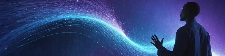 A dark figure of a person with raised right hand looking at a wave of streaming digital lights