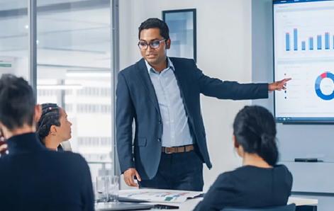 Person presenting business charts to colleagues in modern office setting