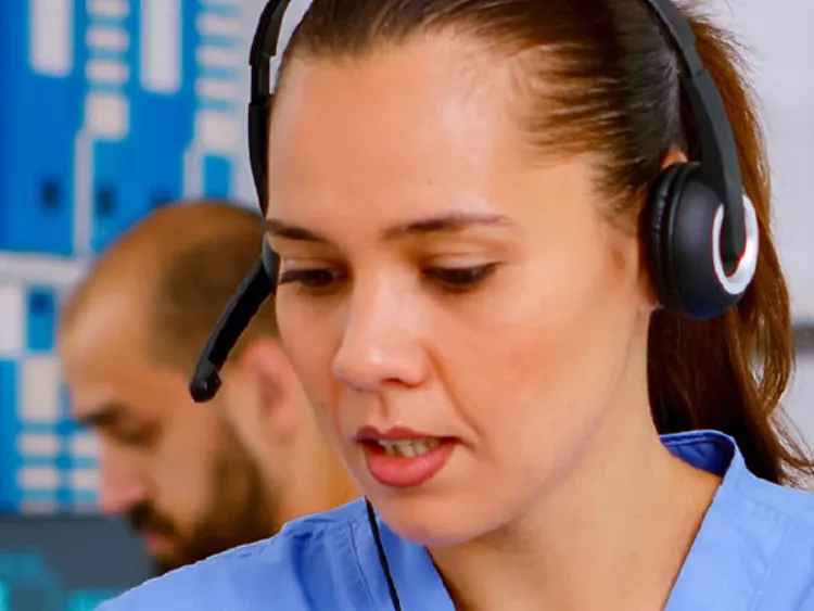 A woman wearing a headset, focused on her work in a busy call center environment