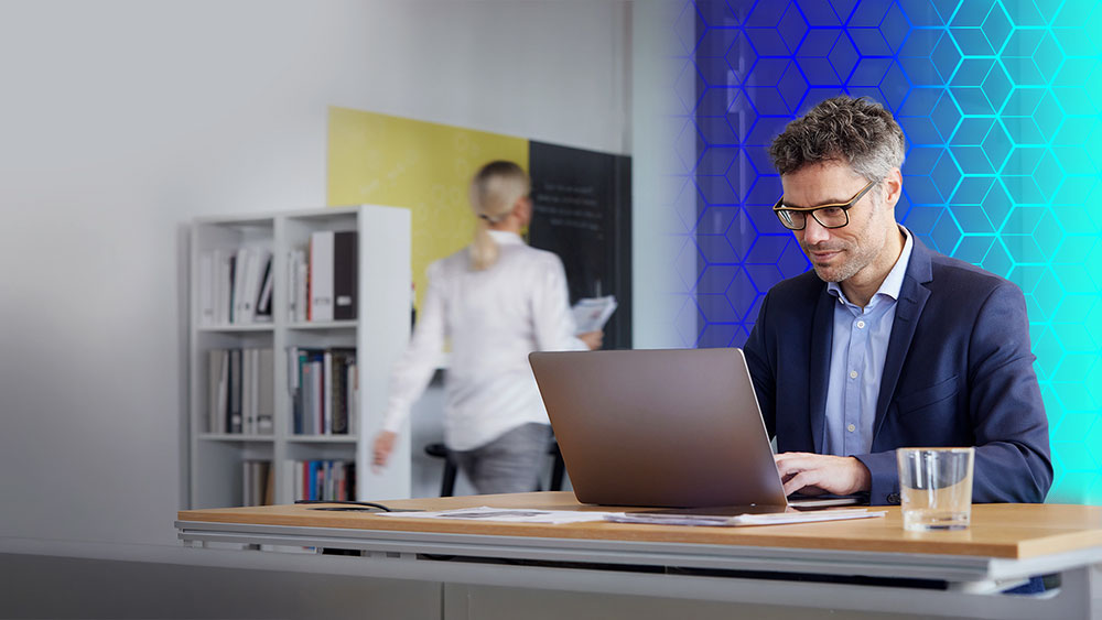 Person working on a laptop at office desk.