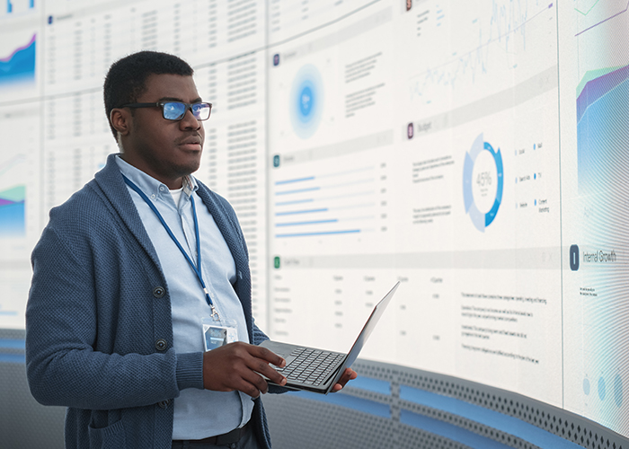 A financial manager looking at a wall screen