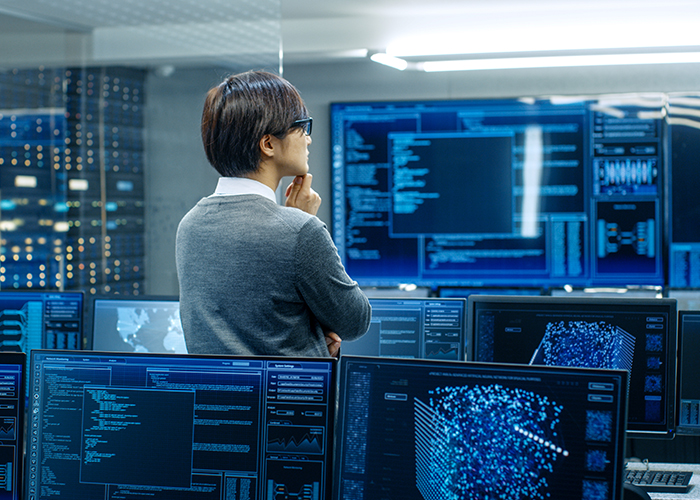 an employee staring at a large screen contemplating