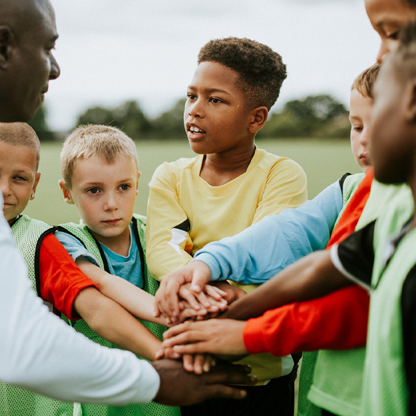 Kids of a team in a huddle with their coach