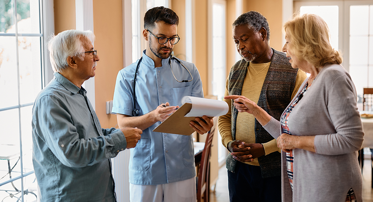 A group of elederly people consulting a doctor