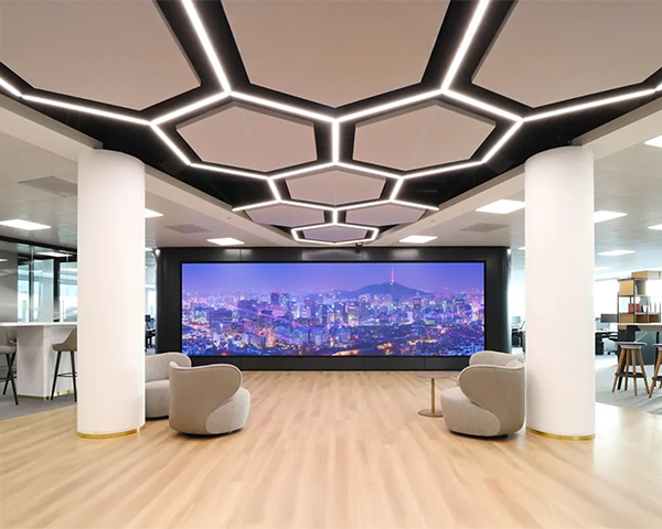 A modern office featuring two large screens, showcasing a sleek and professional workspace environment.