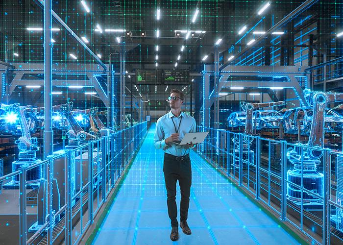 Photo of a man in a factory observes digital data visualizations for production analysis