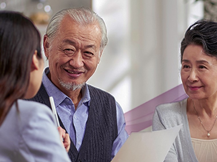 A professional explaining something on a paper to an old couple