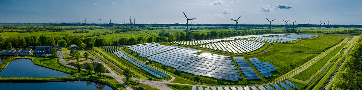 A sustainable energy installation with wind turbines and solar panels.