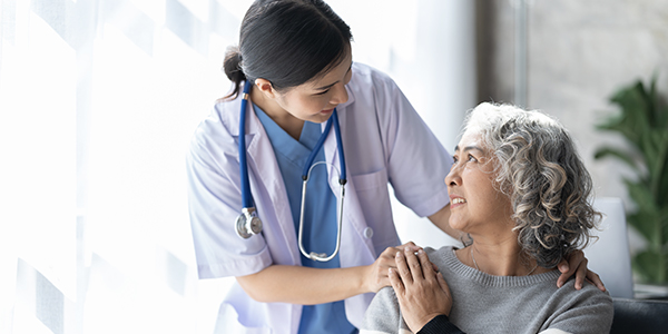 A nurse assists an elderly woman, providing care and support in a compassionate healthcare setting.