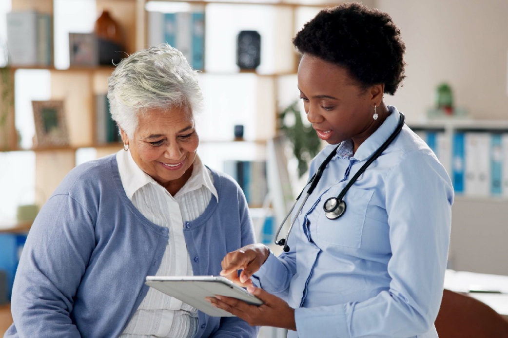 A young nurse showing a report to an elderly woman