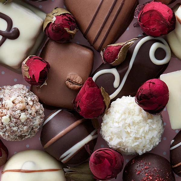 ein Aufstrich Pralinen und ein paar rote Rosen