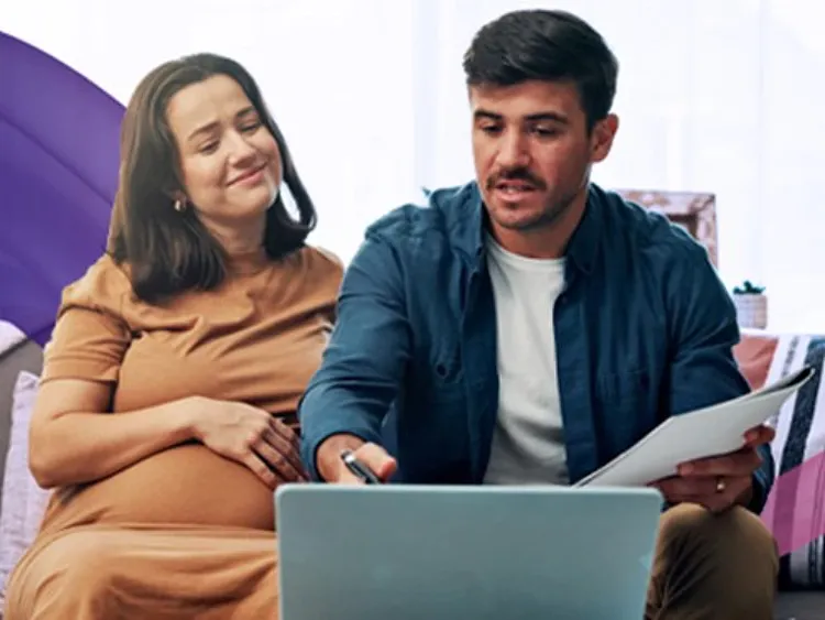 A pregnant woman and man watching laptop