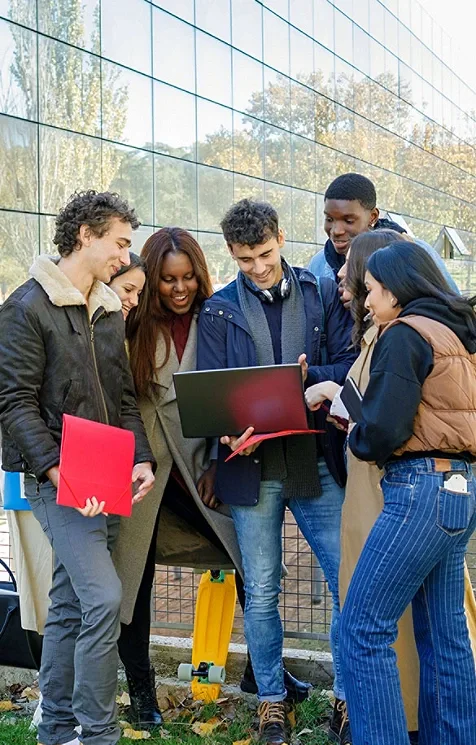 Group of young adults looking at laptop together
