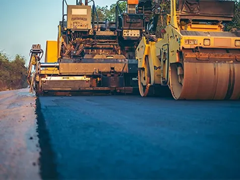 A road roller compacting asphalt while building a road