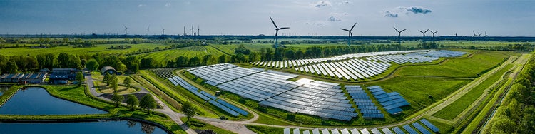 A sustainable energy installation with wind turbines and solar panels.