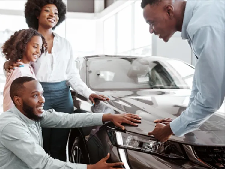 A salesman and a family looking at a car.