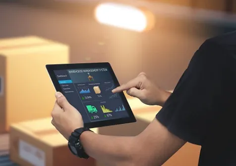 A person working on a tablet, viewed from behind their left shoulder