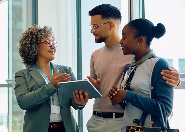 A professional lady holding a notebook explaining something to a couple
