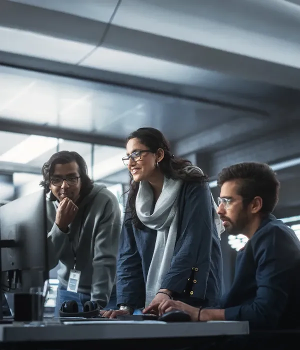 Three individuals focused on their computers