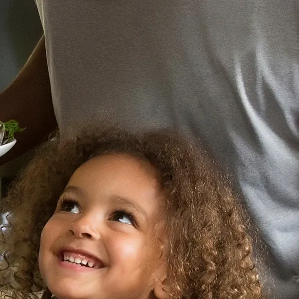 Face of little girl in front of another person who is standing