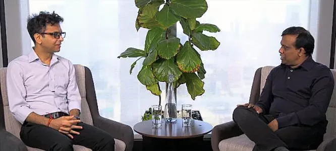 Two people sitting across a small round table to have a discussion