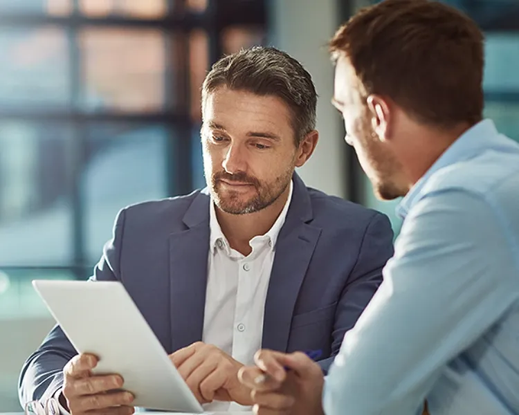 Two professional man discussing each other by focusing on Tablet