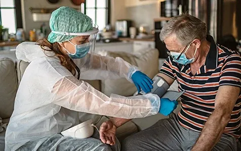 A medical professional with a patient, putting on a blood preasure cuff on his arm
