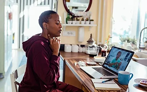 A woman attentively viewing a presentation on the laptop