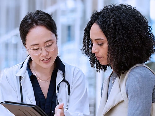 Healthcare professional sharing information on a tablet with a woman