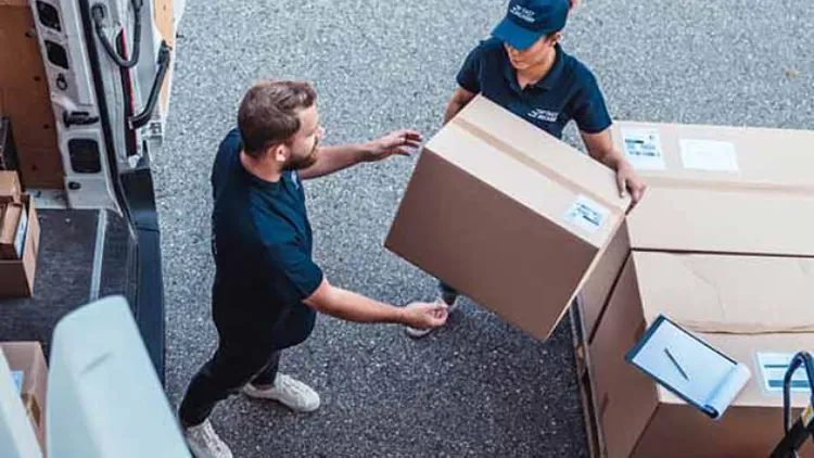 Two men handling boxes.