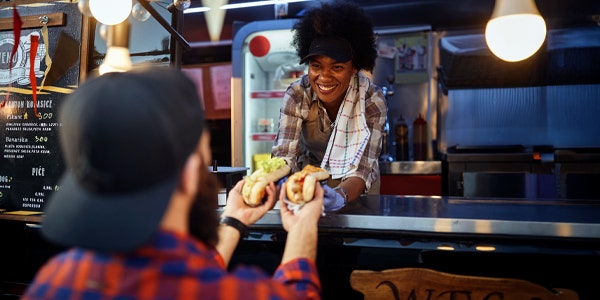 A women employee giving a sandwiches to a customer