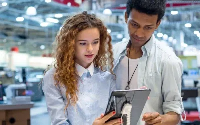 Two customers checking out a tablet at a store