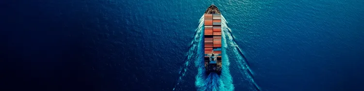 A container ship with vast deck and cargo in a blue sea