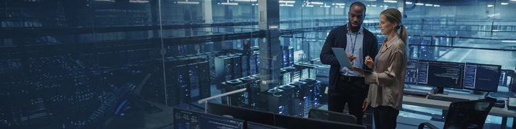 A man holding a laptop along with a female colleague and both are looking into it inside a work environment