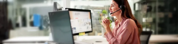 An insurance professional having a discussion with a female customer sitting on a table with a laptop open