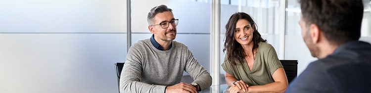 Three people discuss agentic AI in mortgage lending office.