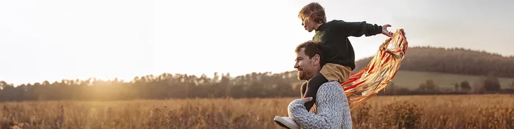 A man and a child are captured in mid-flight, sharing an exhilarating experience as they glide through the air.