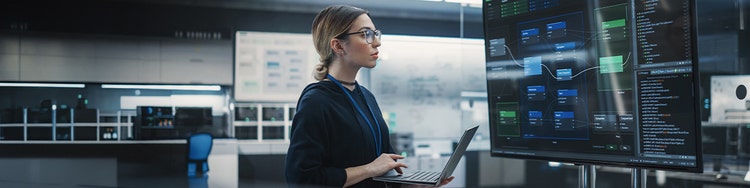 Professional using laptop examining AI workflow diagrams on digital screen
