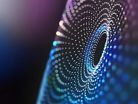 A man walking on a bridge towards light.