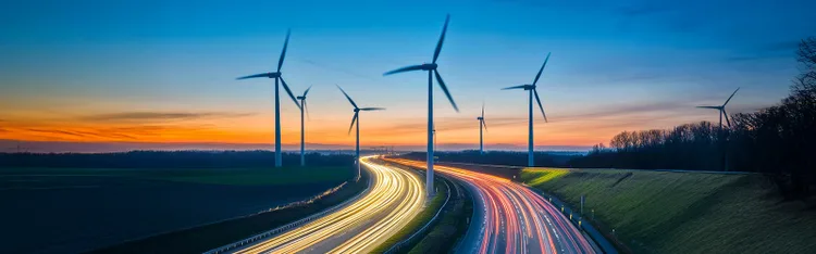 Evening view of windmills over roads.