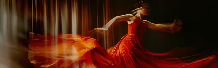 Dancer in red dress spinning with motion blur
