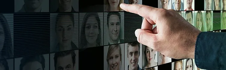 finger pointing at a screen full of people