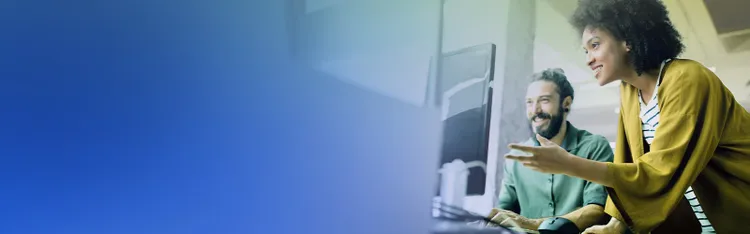 A man and a woman focusing on desktop in office