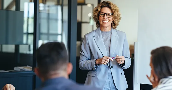 A woman engages in conversation with team mates.