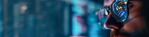 A person wearing glasses looking at a screen