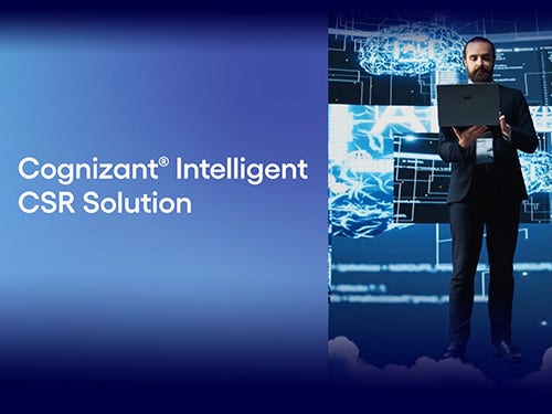 A suited man is standing and looking at an open laptop